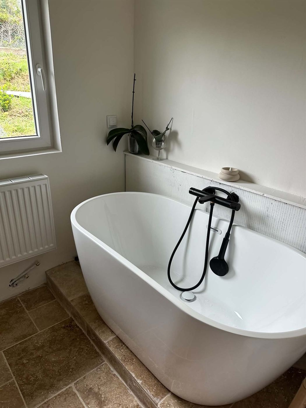 Salle de bain avec baignoire îlot et robinetterie noire