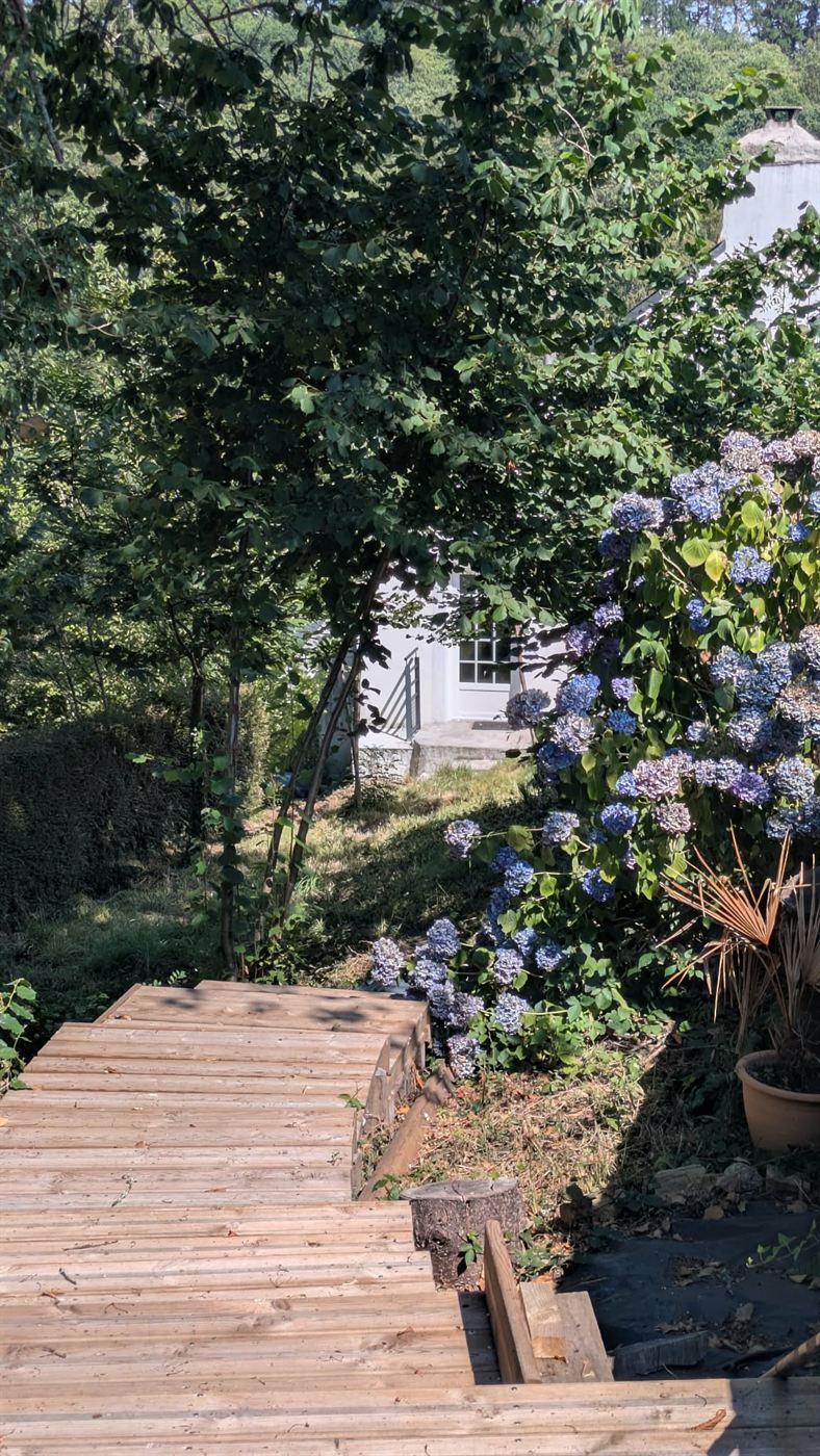 Terrasse en bois donnant sur un jardin fleuri